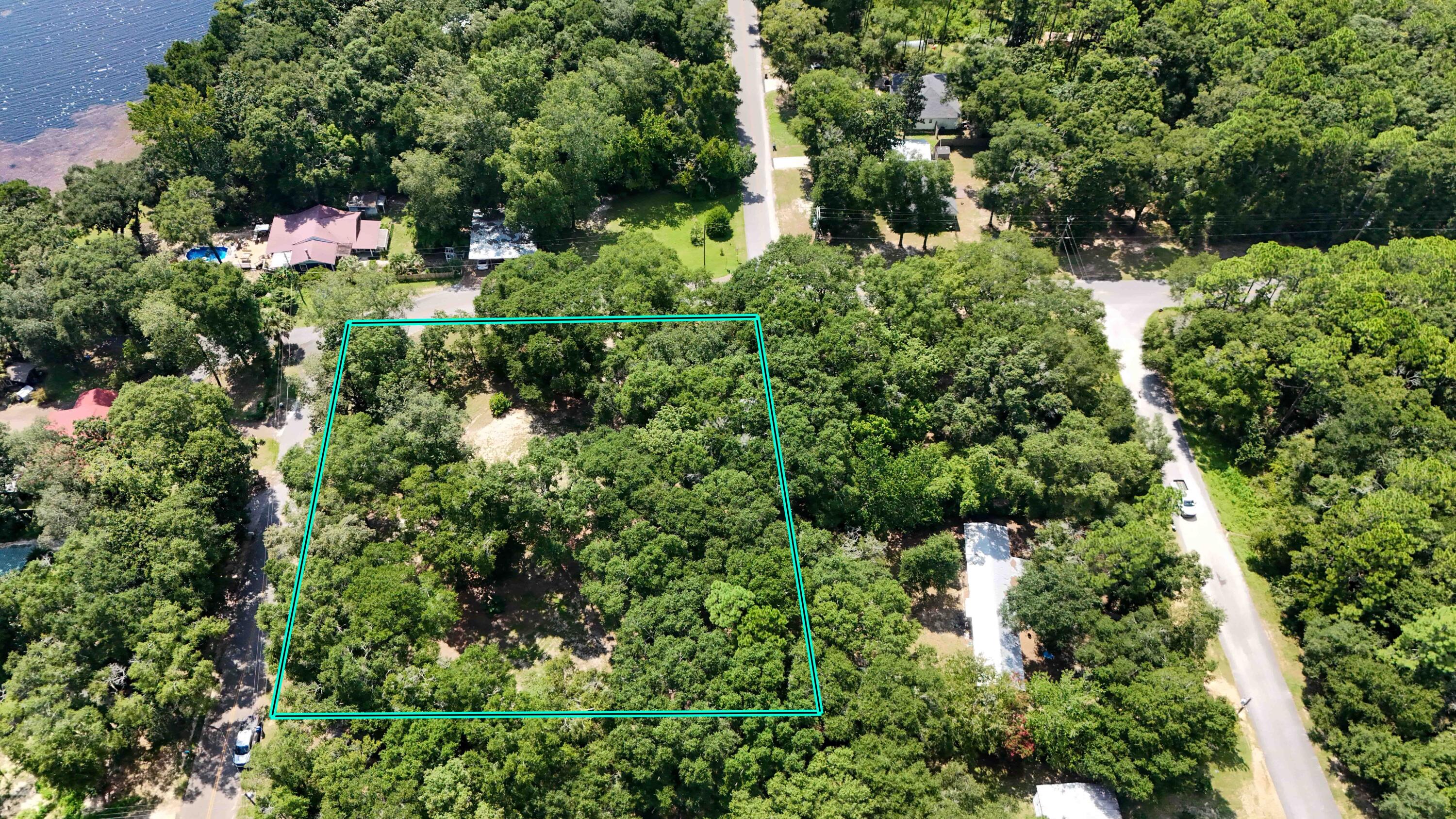 an aerial view of residential house with outdoor space and trees all around