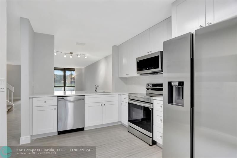 a kitchen with stainless steel appliances granite countertop a stove top oven a sink and dishwasher