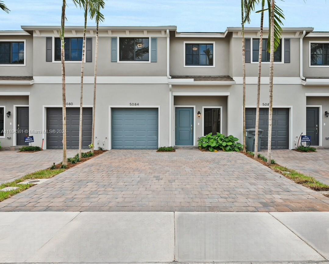 a front view of a house with a yard and a garage