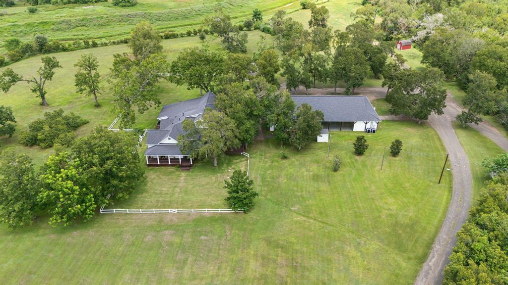 an aerial view of residential house with outdoor space and trees all around