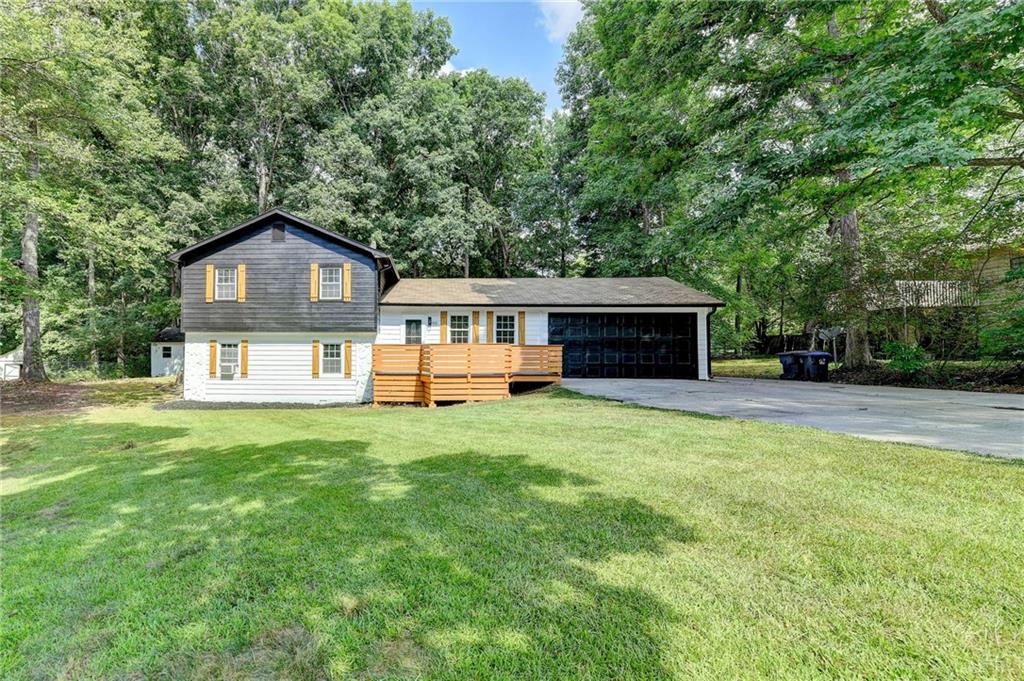 a front view of a house with a yard and trees