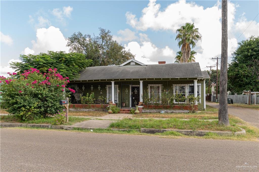 a front view of a house with a yard and fountain