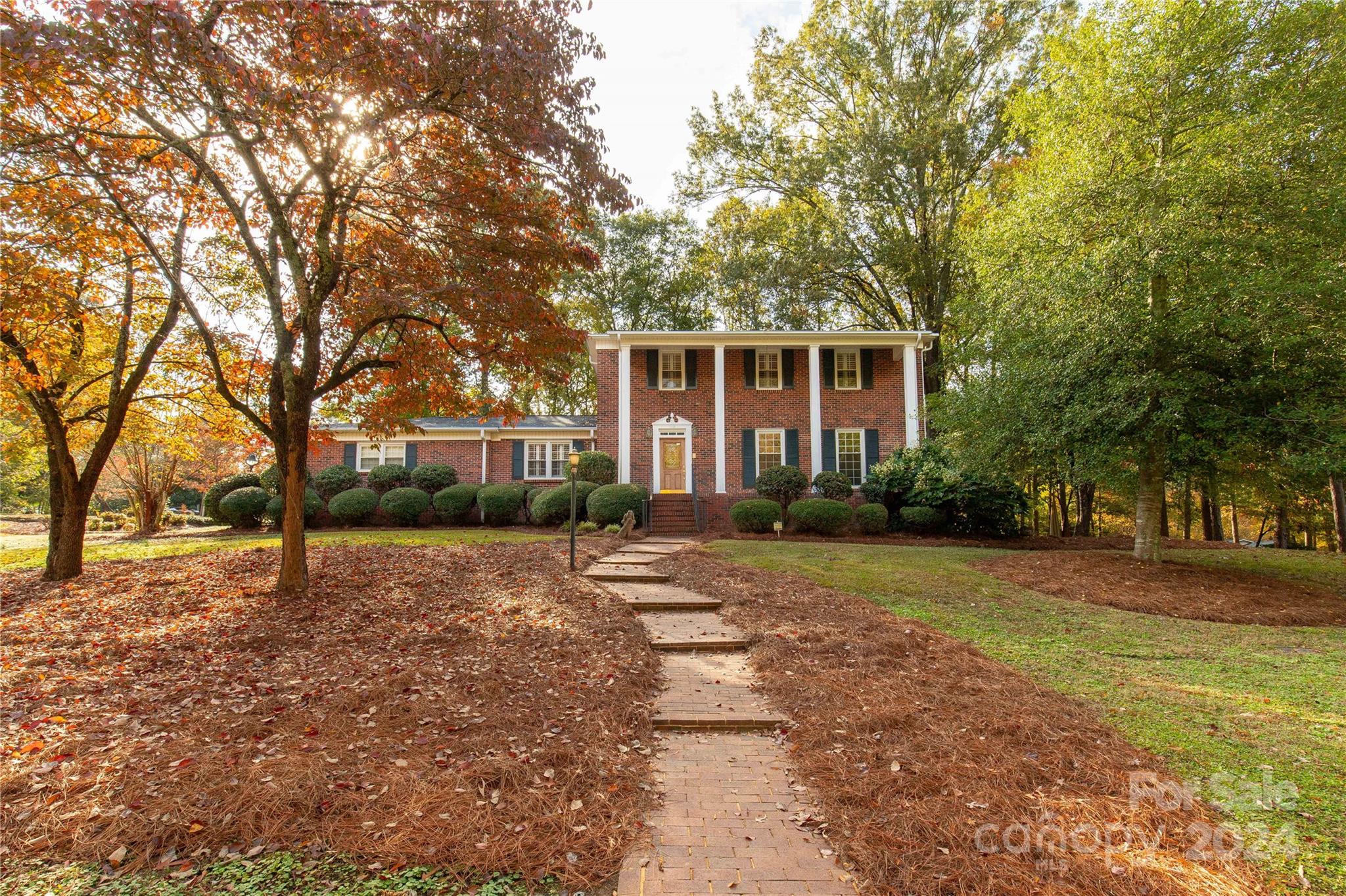 a front view of a house with a yard and trees