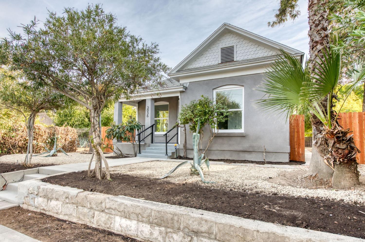 a front view of a house with a yard and tree