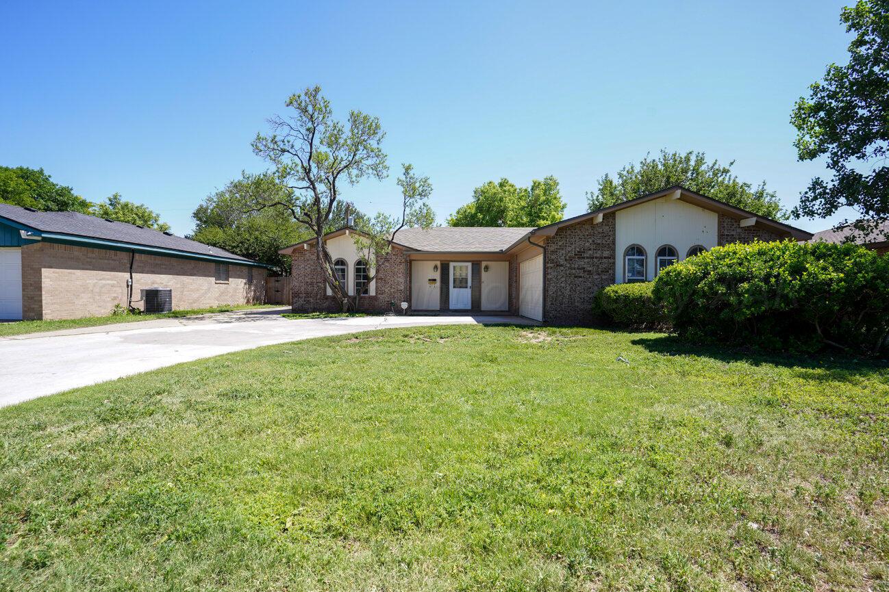 a front view of house with yard and green space