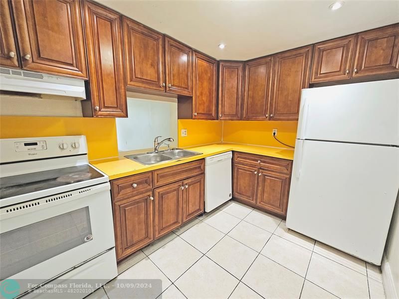 a kitchen with a cabinets a sink and a stove top oven