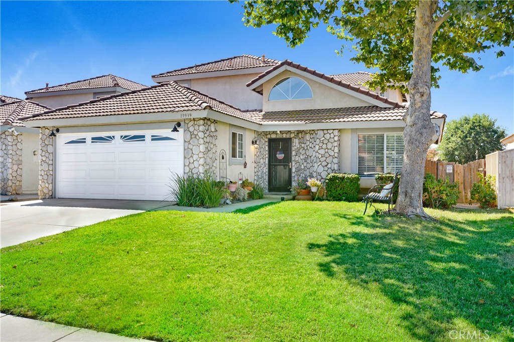 a front view of a house with a yard and potted plants