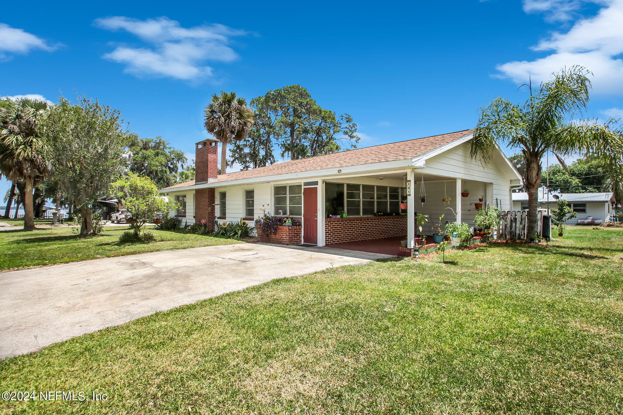 a view of a house with a yard and palm tree