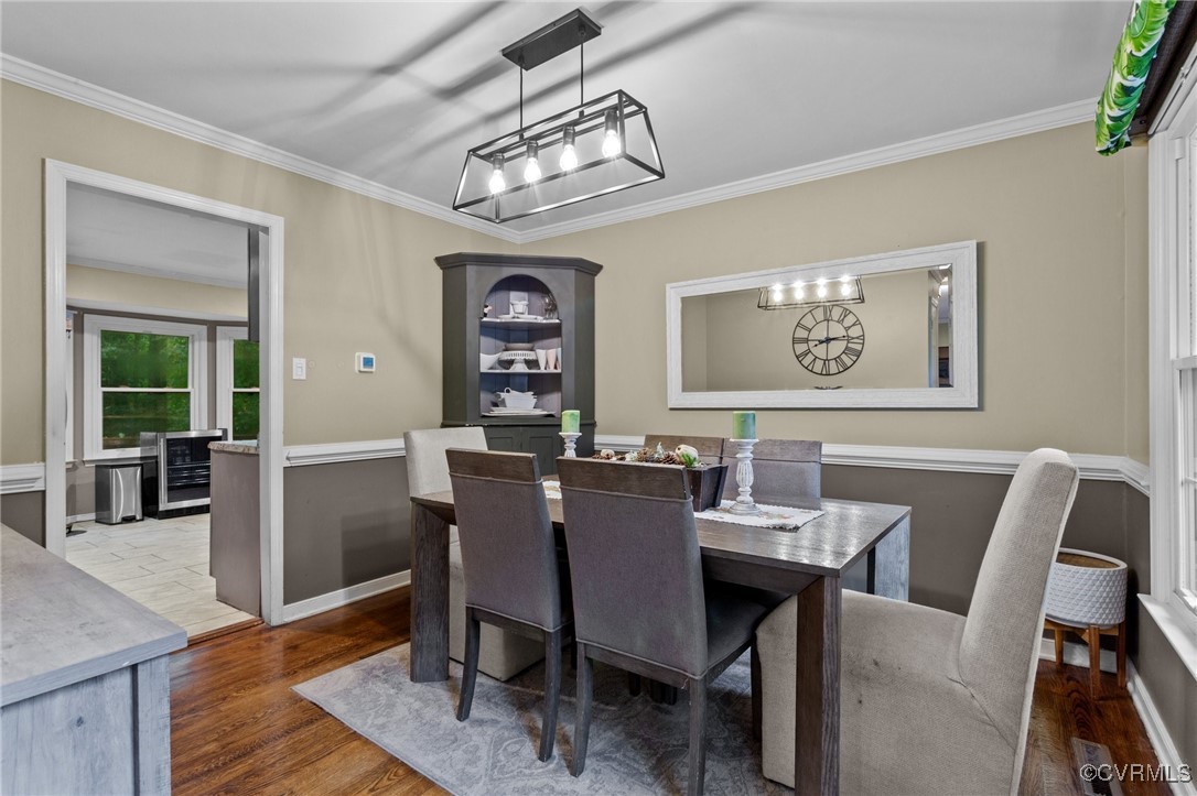 a view of a dining room with furniture a chandelier and wooden floor