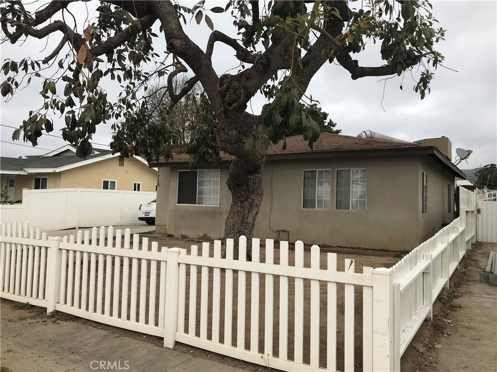 a front view of a house with a tree