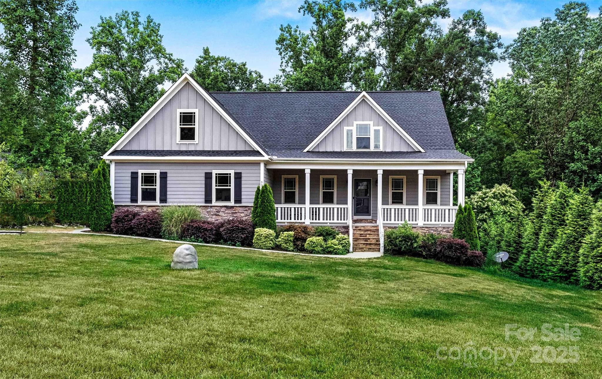 a front view of a house with a yard and trees