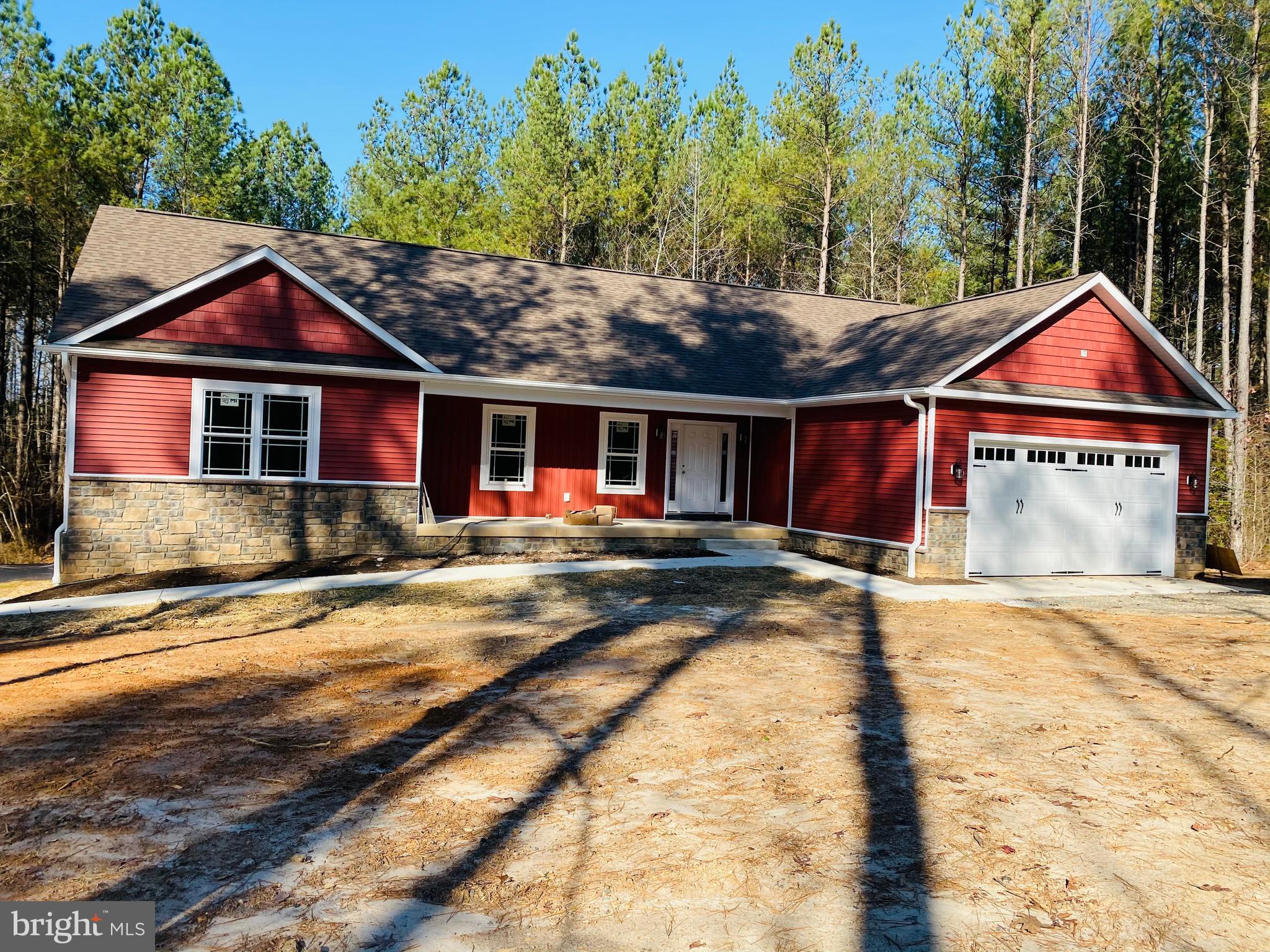 a front view of a house with a yard and trees