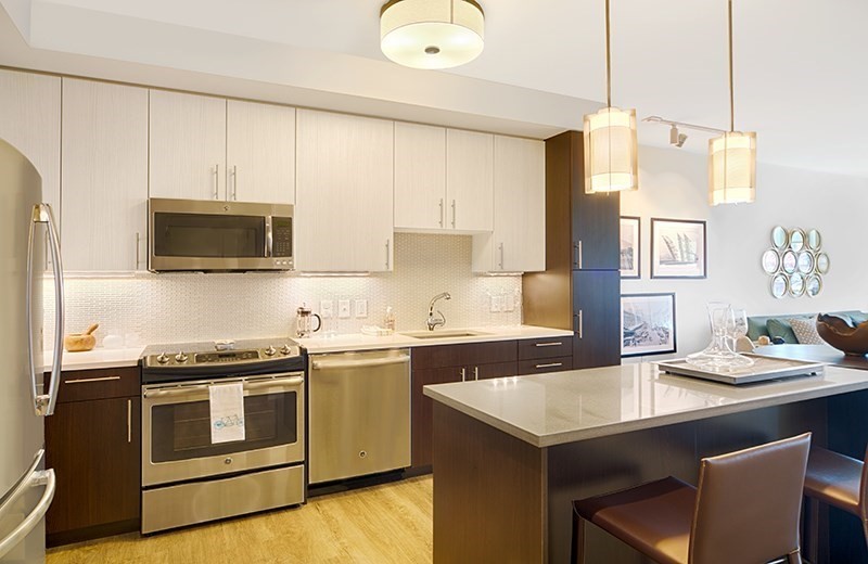 a kitchen with stainless steel appliances granite countertop a stove a sink and a microwave