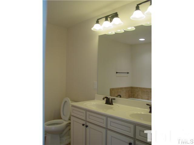 a bathroom with a sink vanity granite and toilet