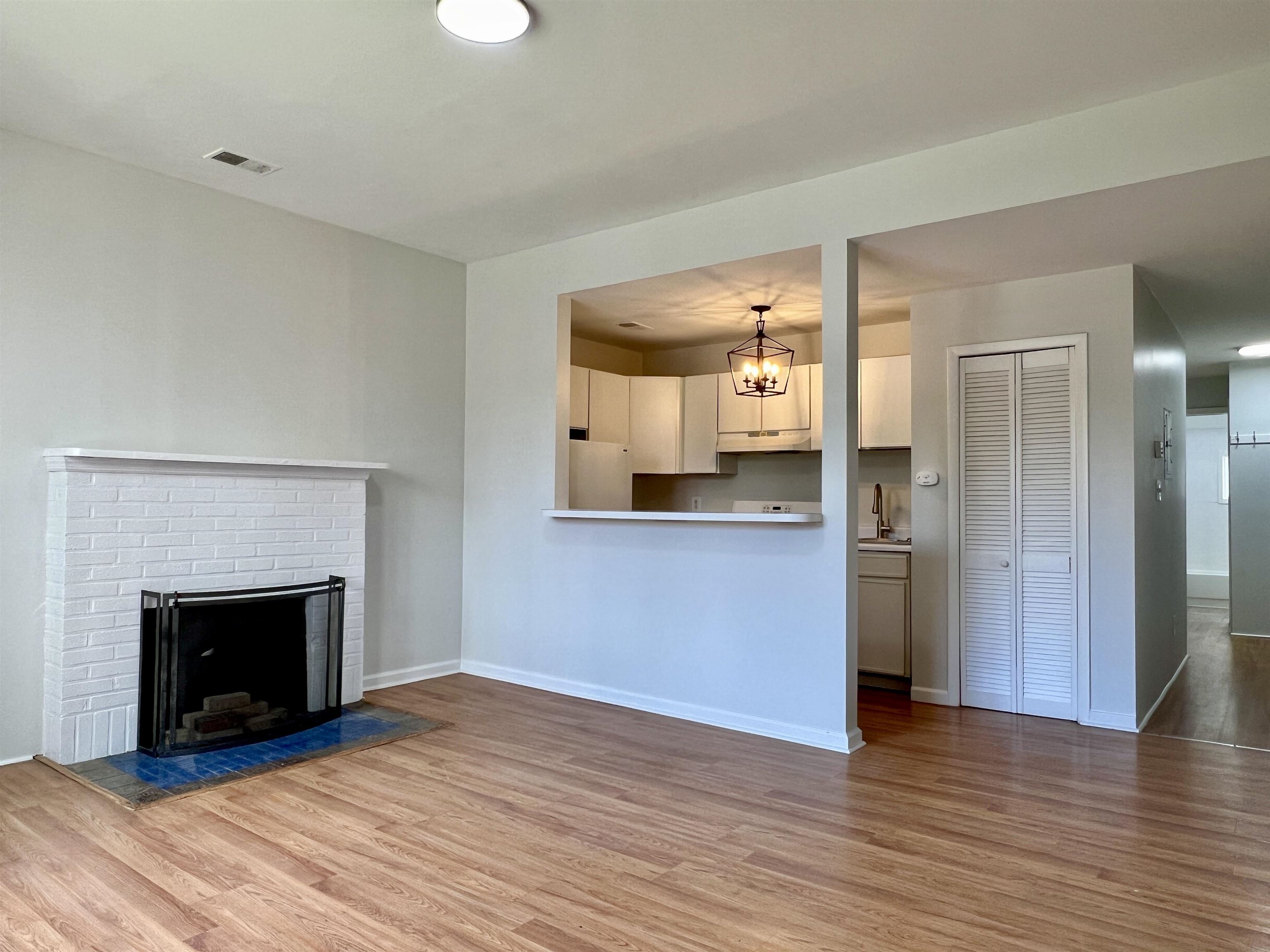 a view of a hallway with wooden floor and a fireplace