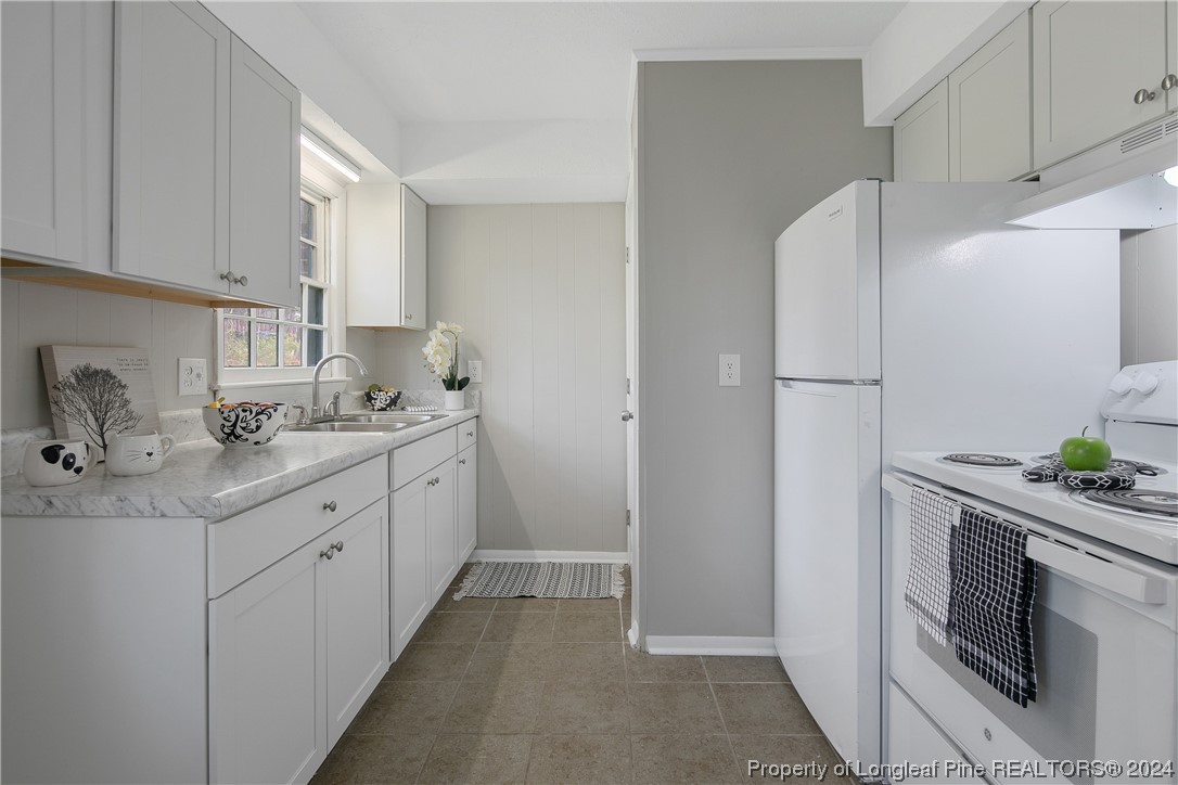 a kitchen with a sink refrigerator and cabinets