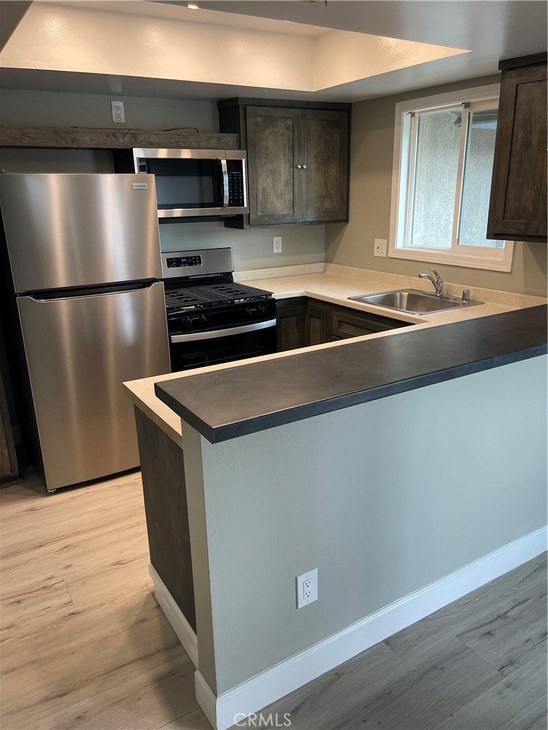 a kitchen with granite countertop a refrigerator and a sink