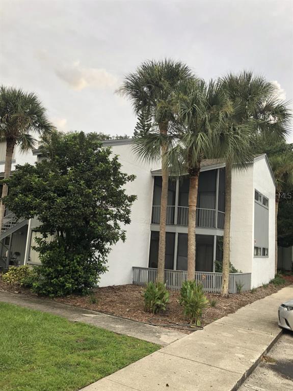 a front view of a house with a yard and trees