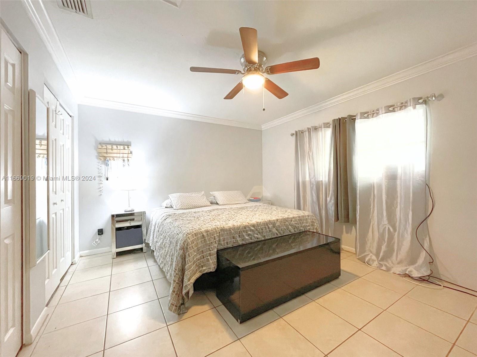 a spacious bedroom with a bed and a chandelier