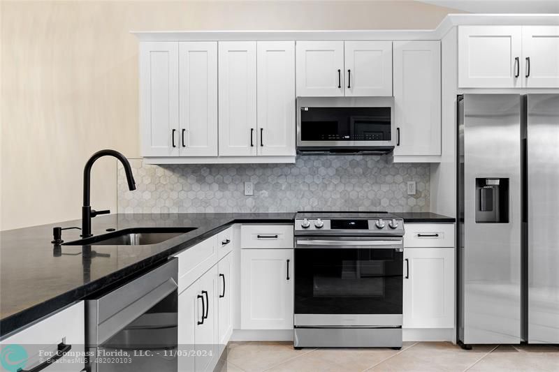 a kitchen with cabinets a sink and stainless steel appliances