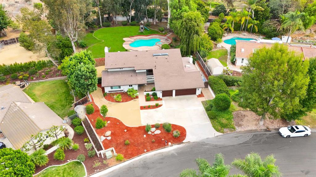 an aerial view of a house with a garden and trees