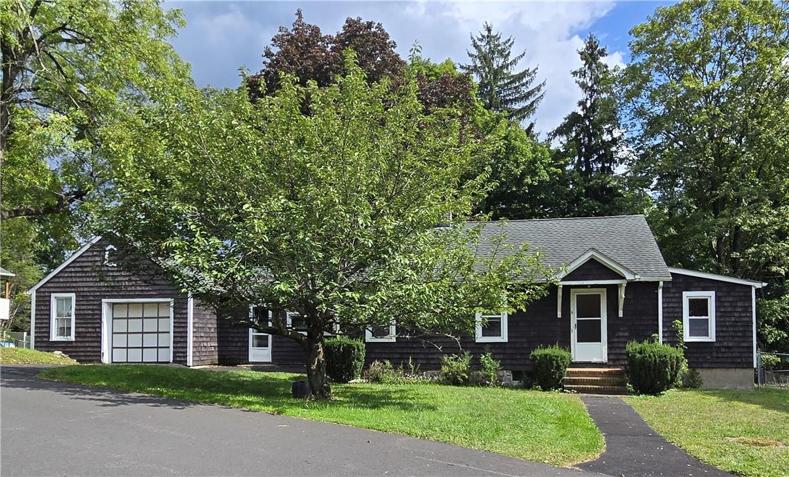 View of front of property with a garage and a front lawn