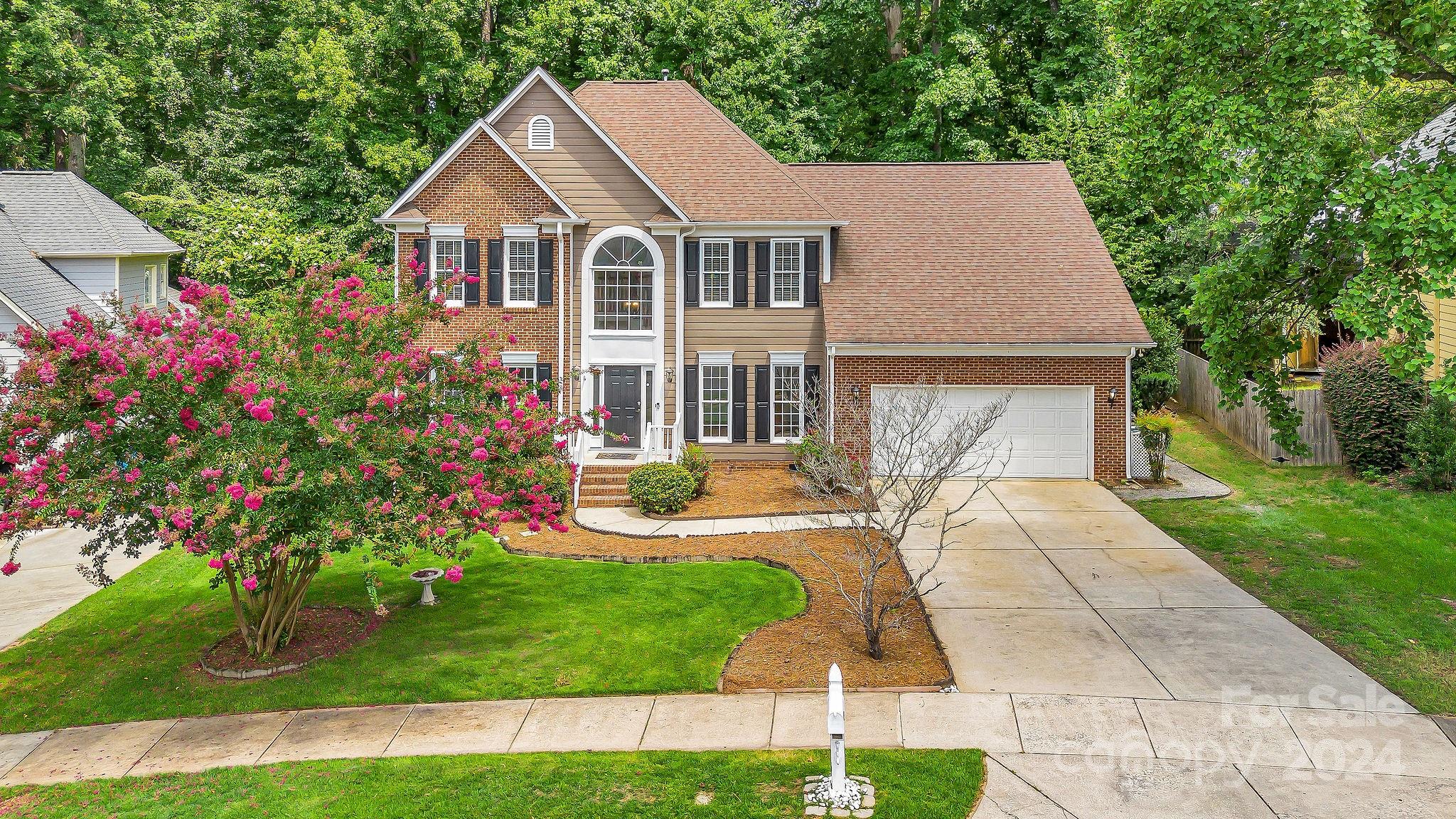 a front view of a house with a yard and fountain