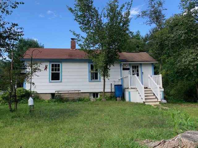 a front view of a house with a garden and yard