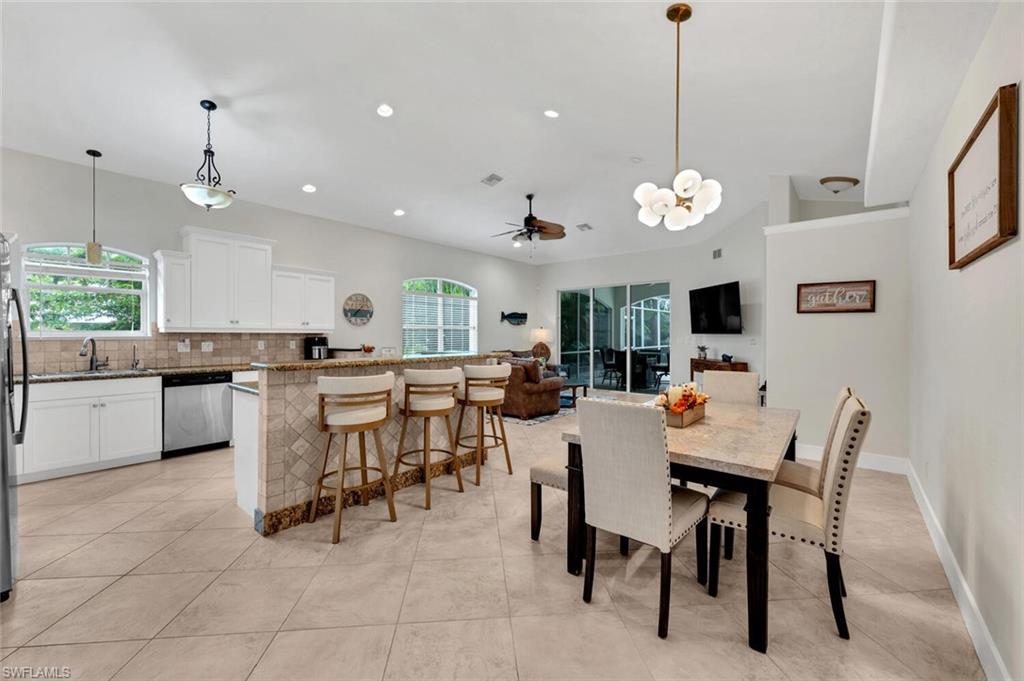 Tiled dining area featuring sink and ceiling fan