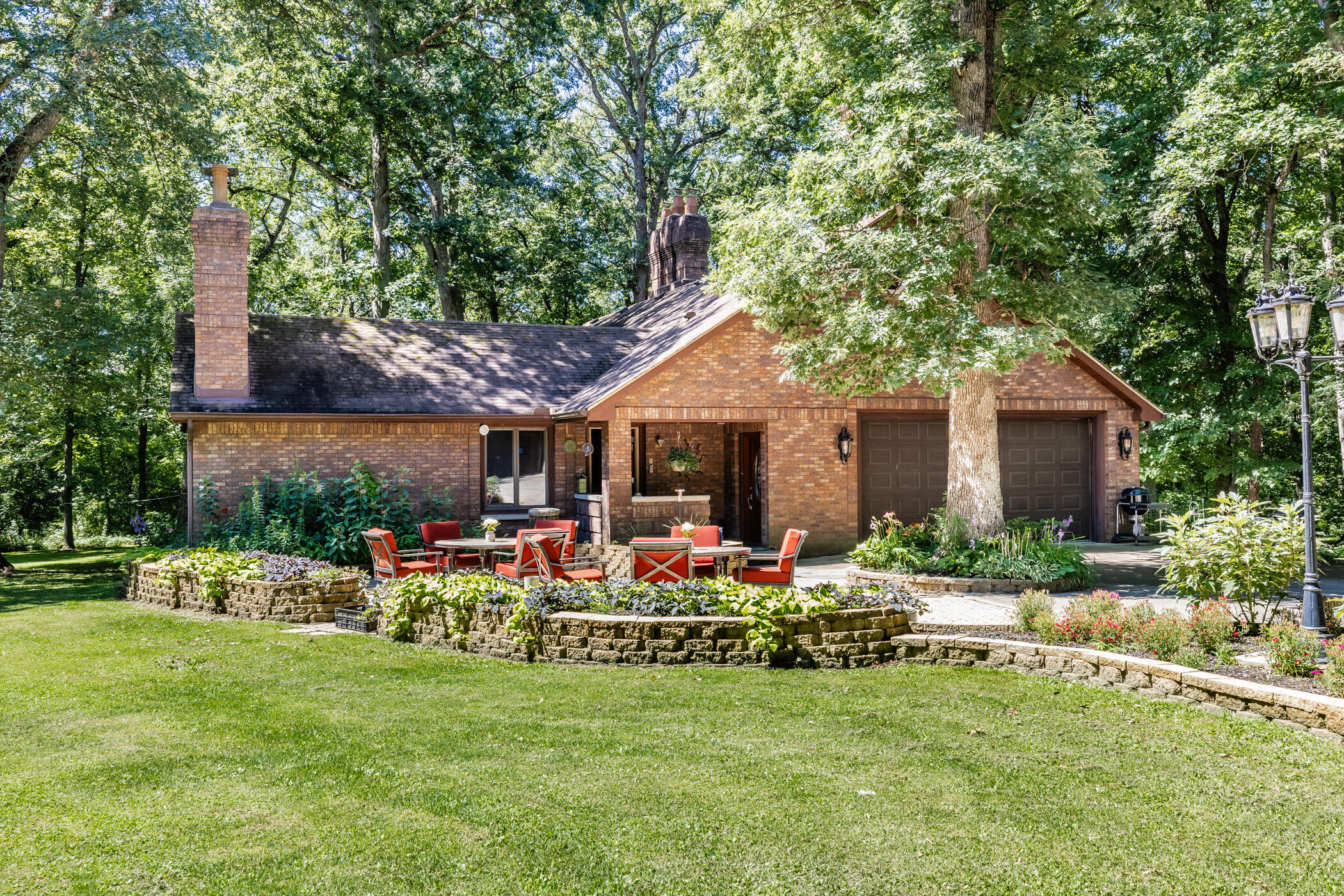 a front view of a house with swing and table and chairs under an umbrella