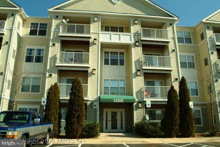 a front view of a residential apartment building with a yard