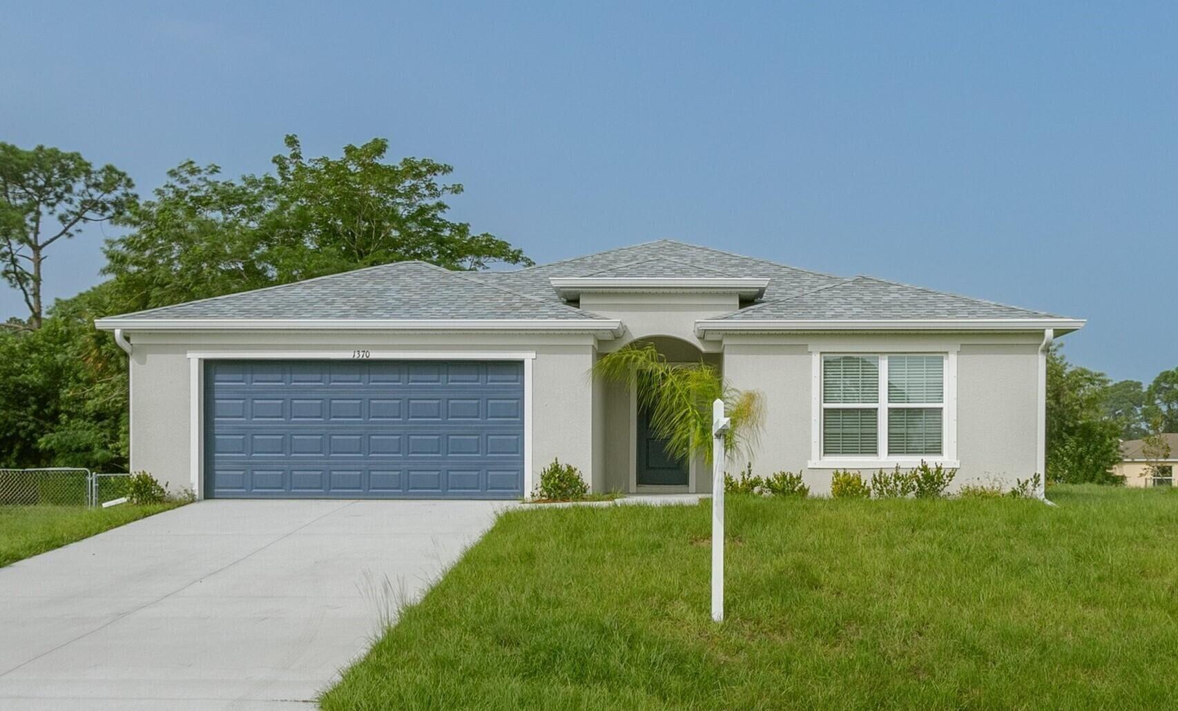 a front view of a house with a garden and yard