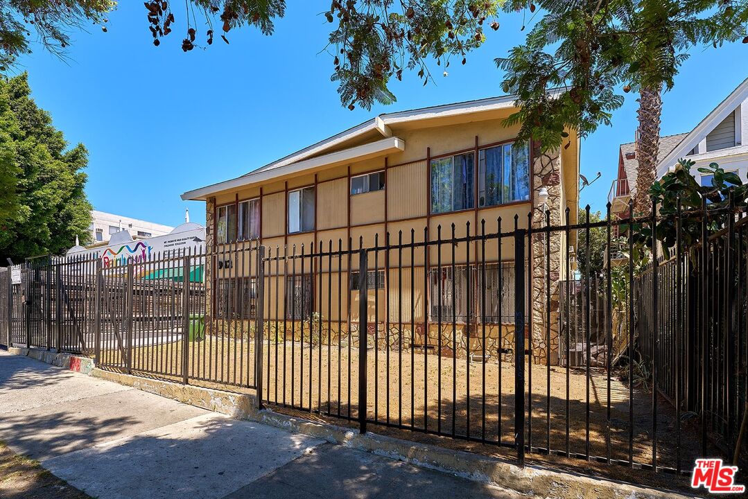 a view of a house with a small yard and wooden fence