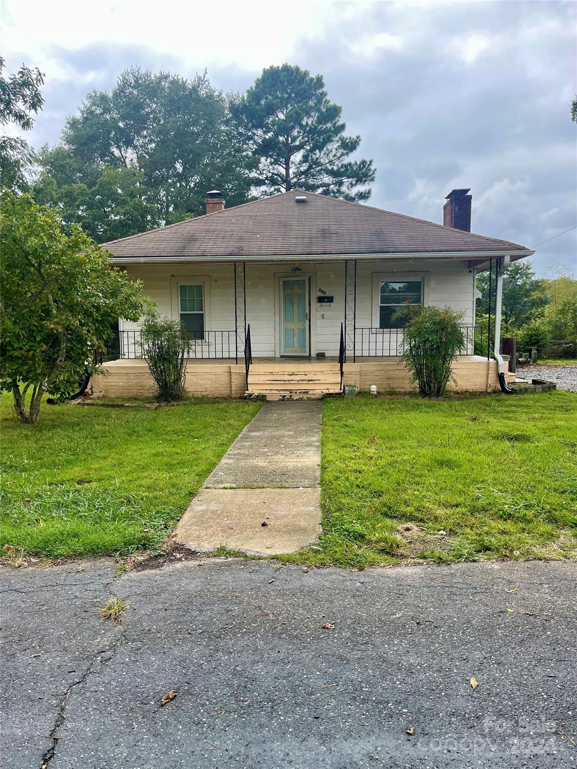 a front view of a house with a yard and plants