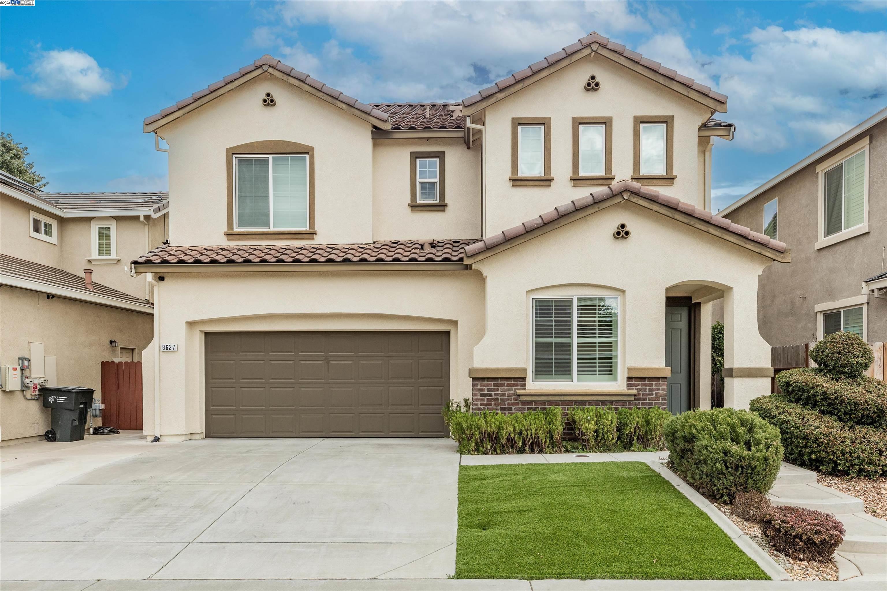 a front view of a house with a yard and garage