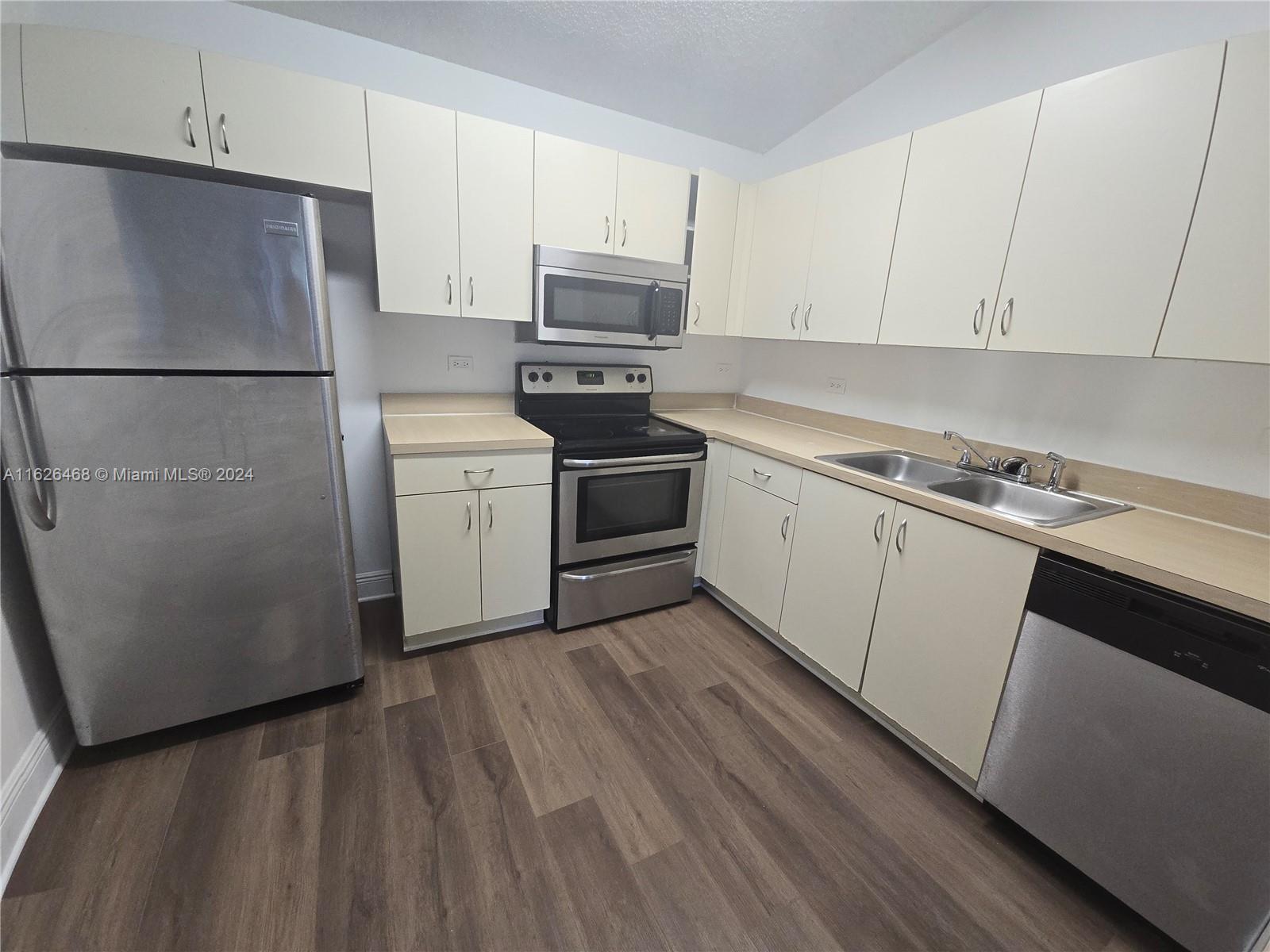 a kitchen with a refrigerator sink and cabinets