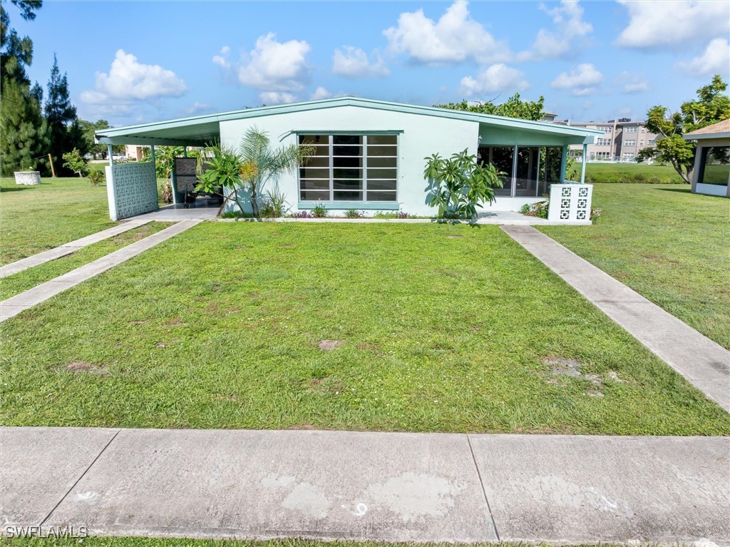 a view of a house with a yard and potted plants