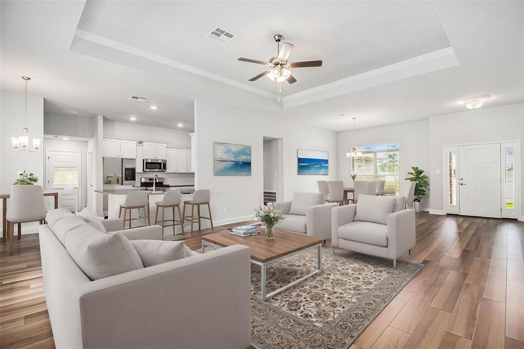 a living room with furniture kitchen view and a chandelier