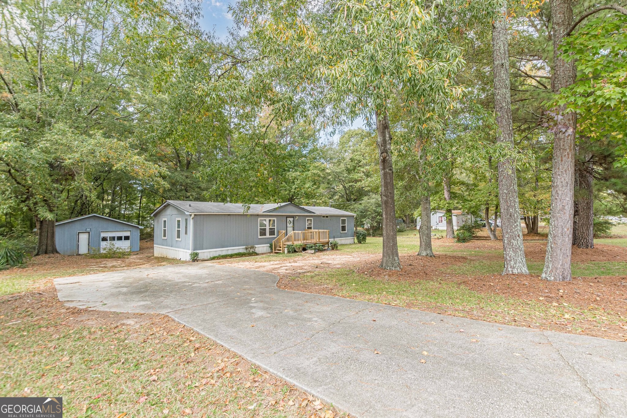 a front view of a house with a road and trees