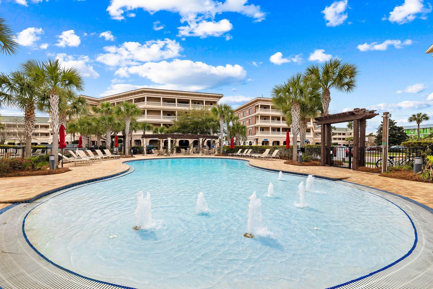 a view of a swimming pool with a lawn chairs under an umbrella