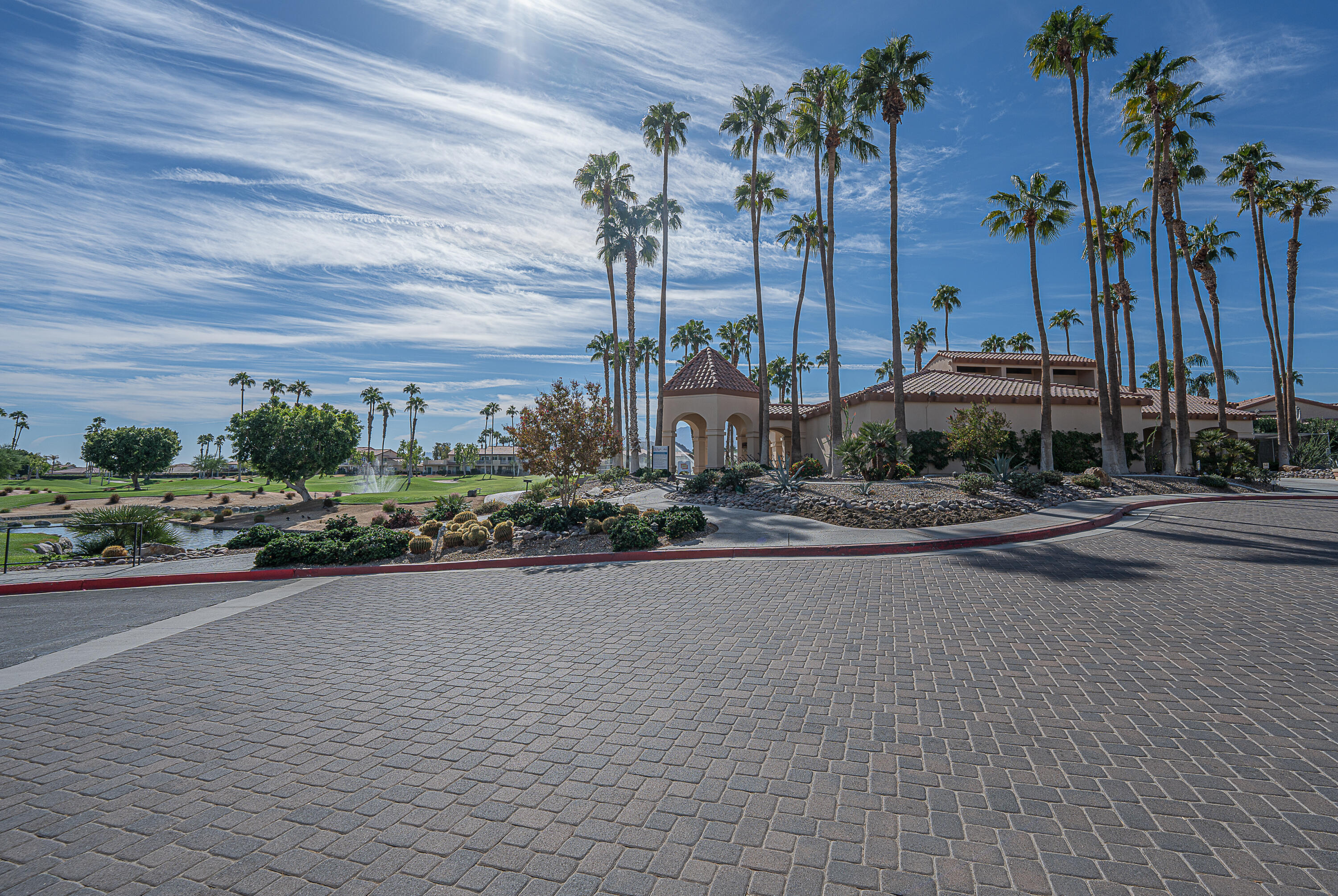 a row of palm trees and a yard in front of the house