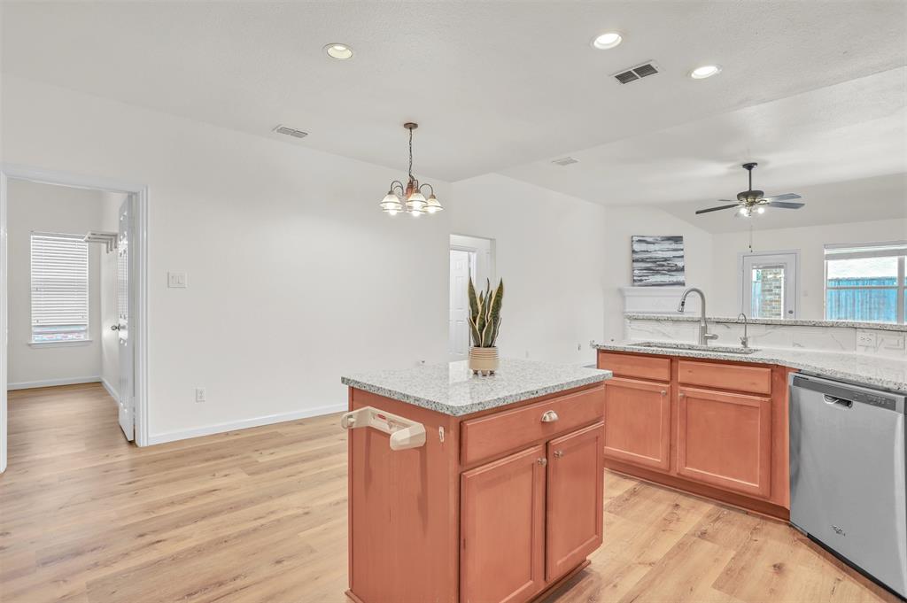 a kitchen with stainless steel appliances granite countertop a sink a stove a refrigerator and a oven with wooden floor