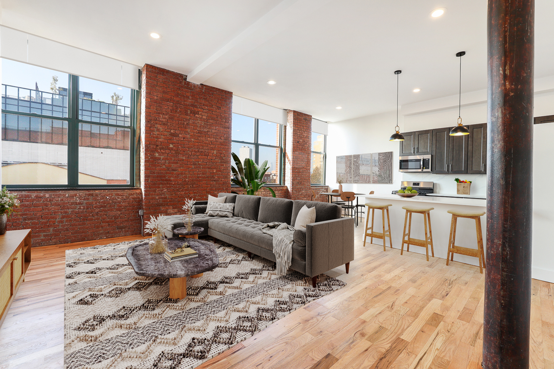 a living room kitchen with stainless steel appliances kitchen island granite countertop a stove a sink a refrigerator white cabinets and couches with wooden floor