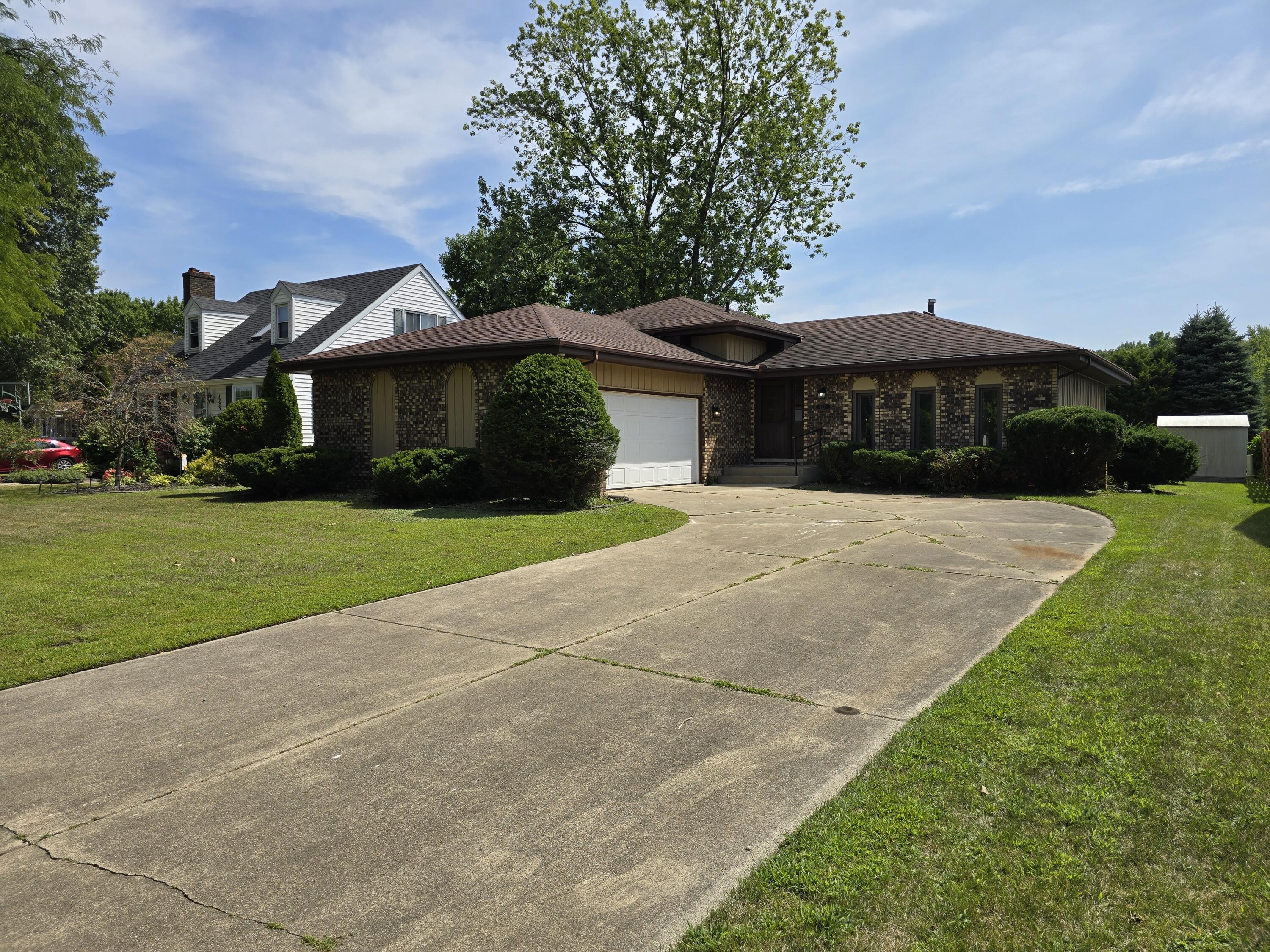 a front view of a house with yard and green space