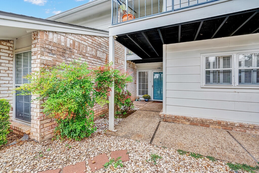 a view of house with potted plants in front of door