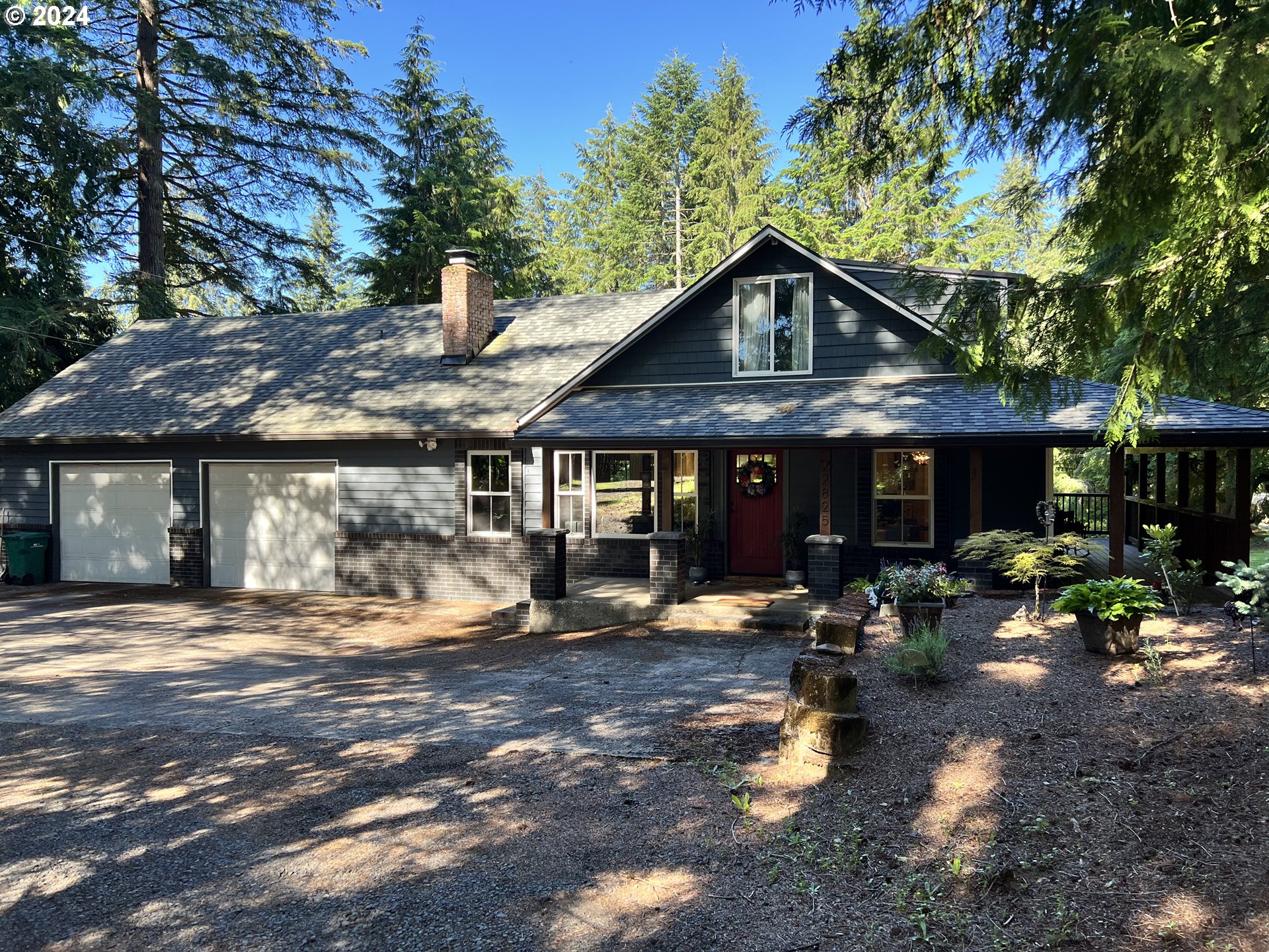 a front view of a house with sitting area and trees