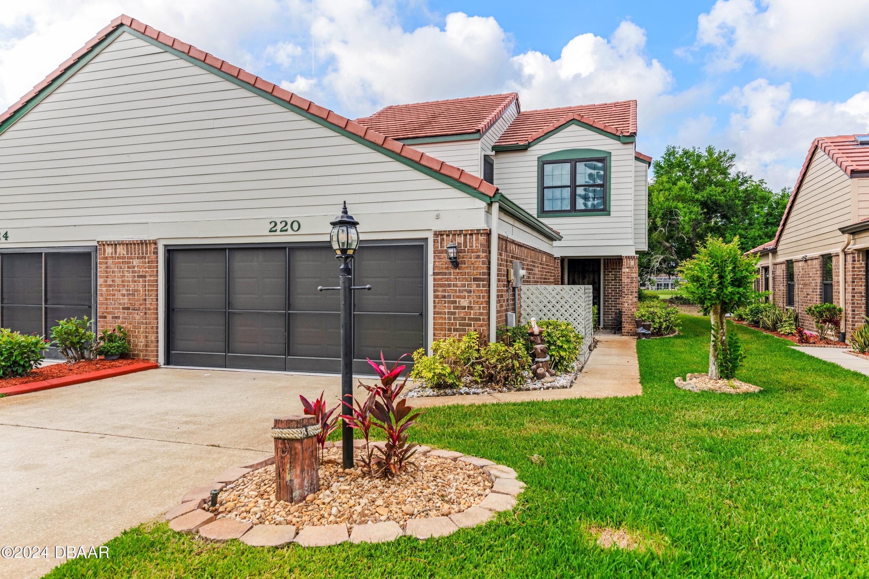 a front view of a house with a yard and a garage