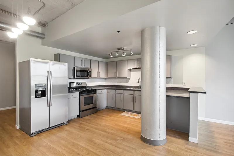 a kitchen with stainless steel appliances a refrigerator and a stove top oven