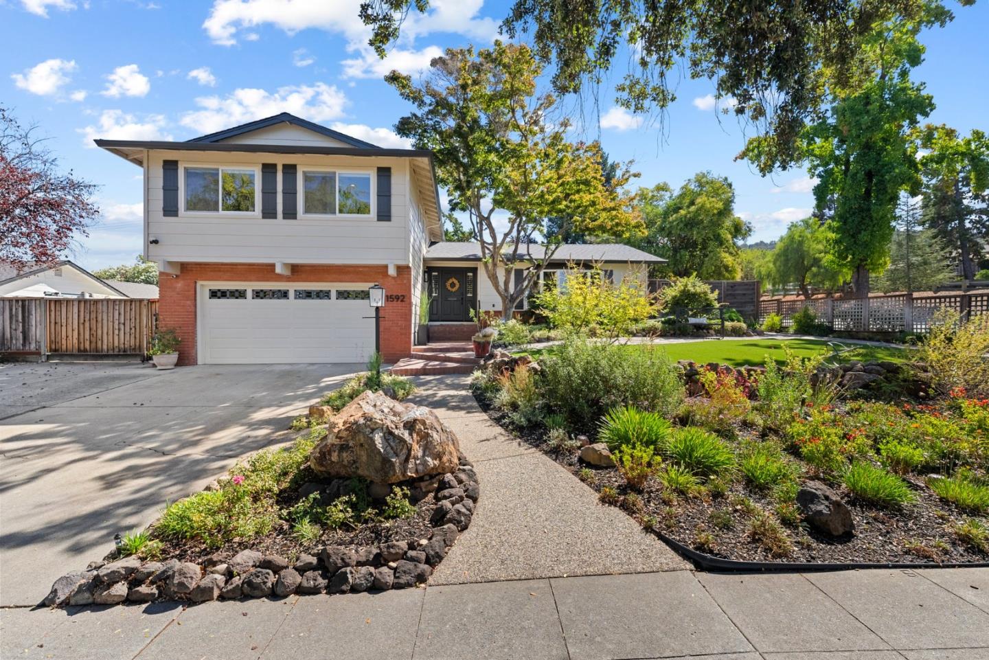 a front view of a house with a yard and a garden