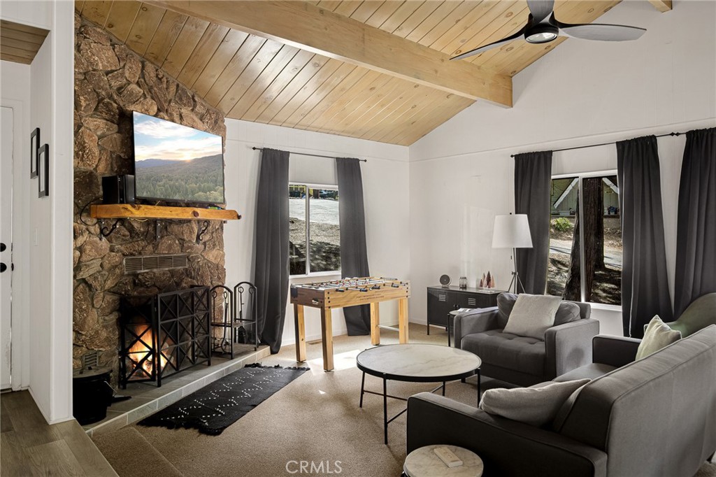 a living room with furniture a fireplace and a floor to ceiling window